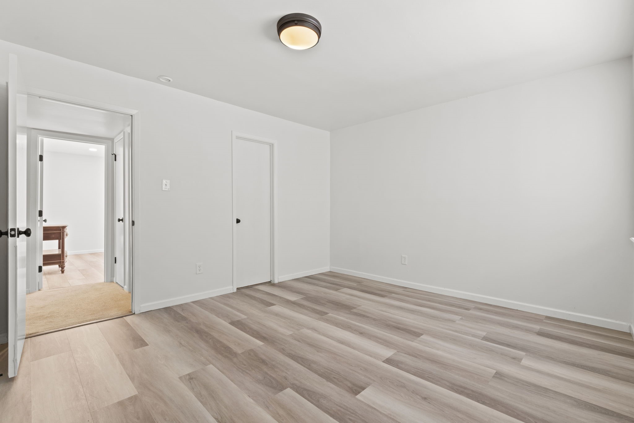 1115 Augusta Drive, Unit 26 Houston, TX 77057 - Photo 17 of 23 Bright and versatile bedroom with light vinyl wood flooring, flush-mount lighting, and closet — ready for your personal touch.