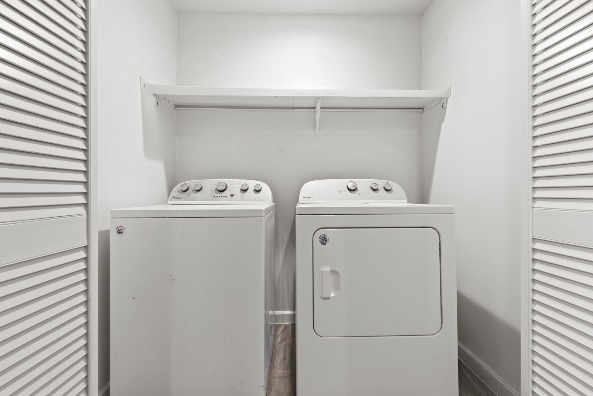 1115 Augusta Drive, Unit 26 Houston, TX 77057 - Photo 18 of 23 Tucked behind louvered doors, this compact laundry nook offers front-loading washer and dryer plus overhead shelving for easy organization.