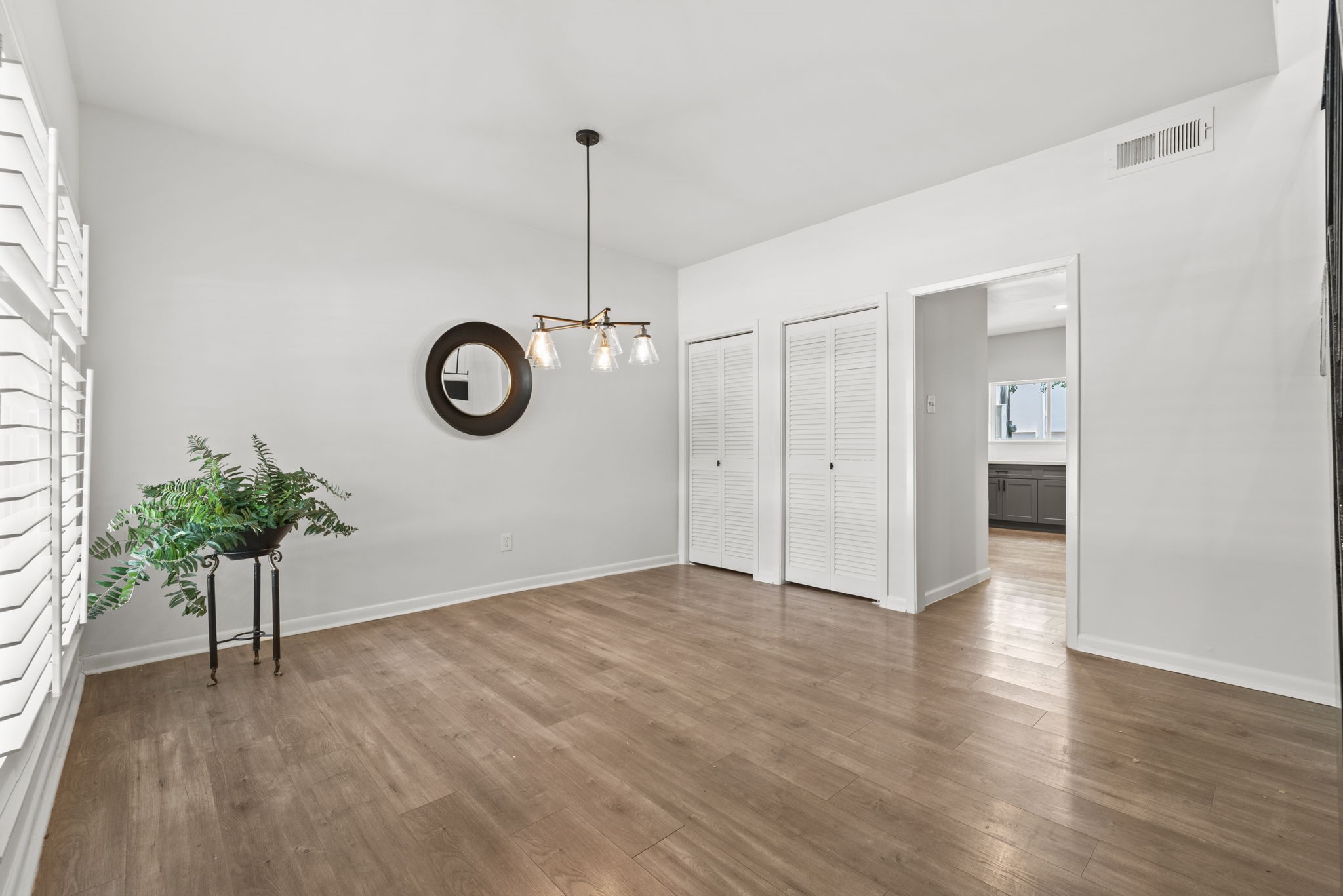 1115 Augusta Drive, Unit 26 Houston, TX 77057 - Photo 6 of 23 Bright dining area with light wood flooring and elegant plantation shutters — offering privacy, natural light, and a timeless touch to this welcoming space. Just off the kitchen for effortless entertaining and everyday convenience.