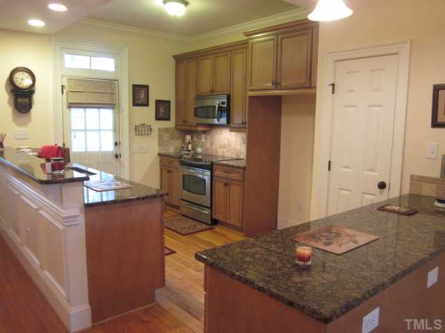 1115 Wake Forest Road, Unit A Raleigh, NC 27604 - Photo 14 of 25 a kitchen with stainless steel appliances granite countertop a sink stove and refrigerator