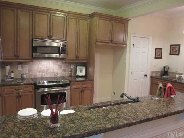 1115 Wake Forest Road, Unit A Raleigh, NC 27604 - Photo 24 of 25 a kitchen with stainless steel appliances granite countertop a stove a sink and a microwave