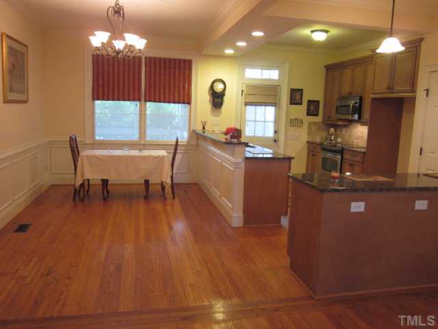 1115 Wake Forest Road, Unit A Raleigh, NC 27604 - Photo 16 of 25 a kitchen with kitchen island granite countertop wooden floors and a view of living room
