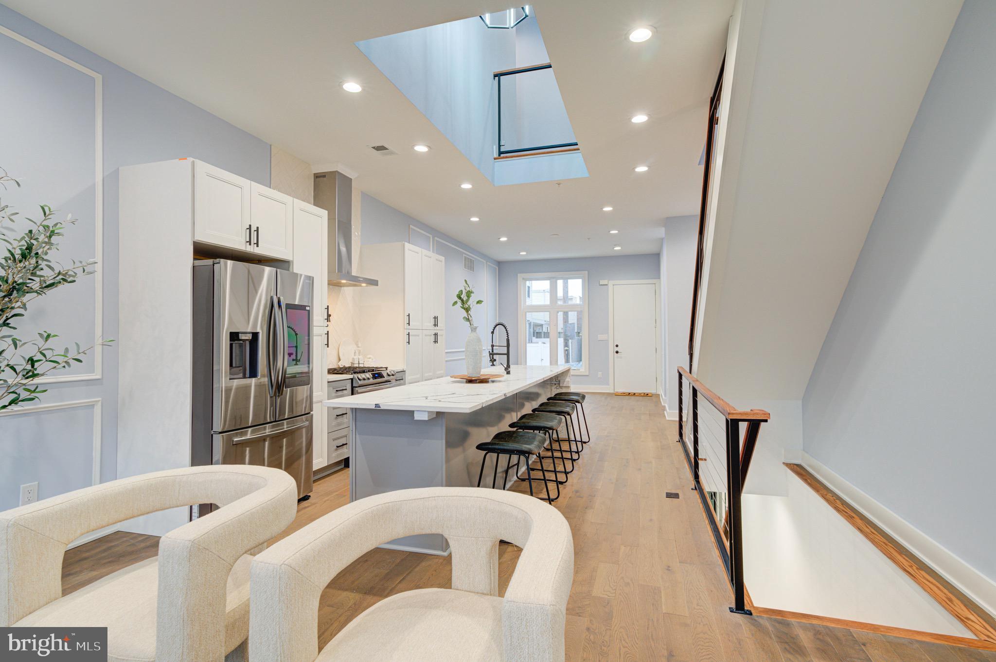 2318 East Hazzard Street Philadelphia, PA 19125 - Photo 11 of 44 a large kitchen with stainless steel appliances refrigerator a dining table and chair with wooden floor