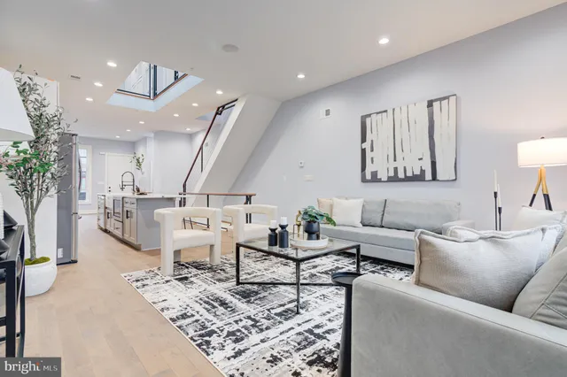 a living room with furniture and view of kitchen
