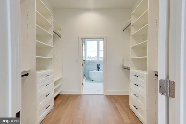 a view of walk in closet with wooden floor