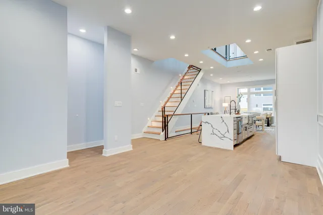 a view of an empty room with wooden floor and stairs