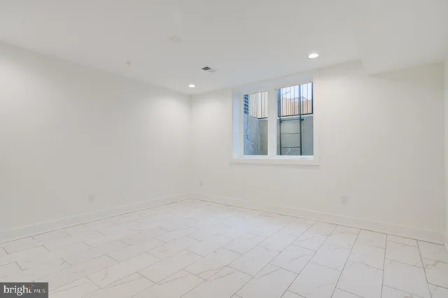 an empty room with white walls and stairs