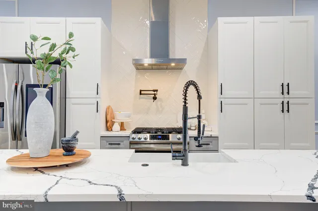 a kitchen with a refrigerator and ceiling fan