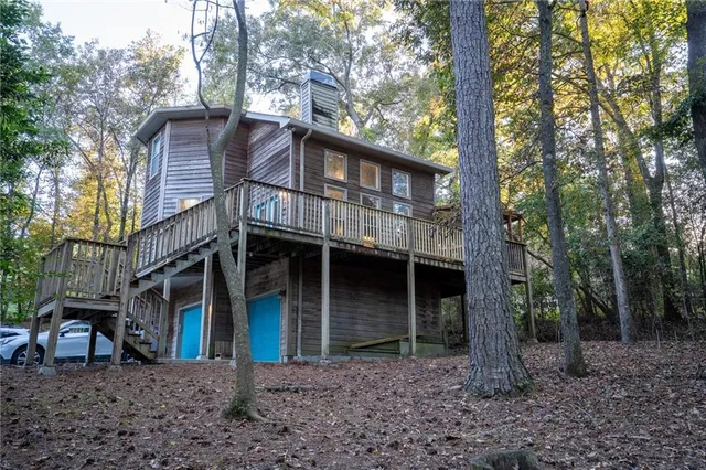 a view of a house with a yard and large tree