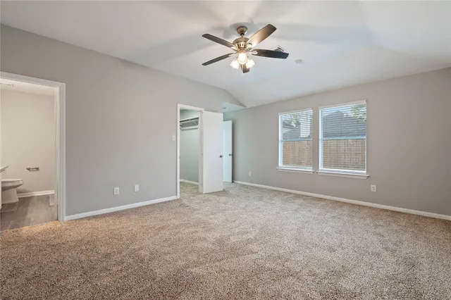 an empty room with closet and a chandelier fan