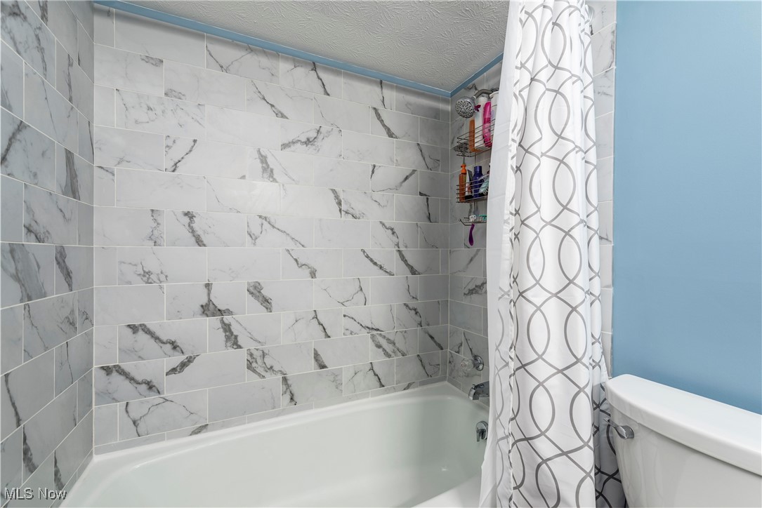 580 Orchardview Road Independence, OH 44131 - Photo 31 of 44 Full bathroom with toilet, a textured ceiling, and shower / bath combination with curtain