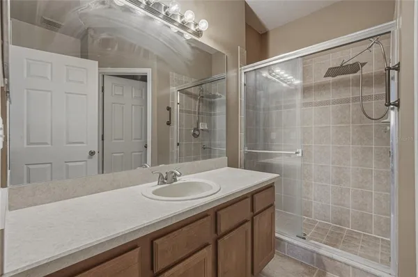 a bathroom with a sink shower and a mirror
