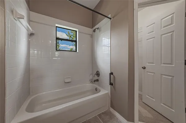 a white bath tub sitting next to a small window