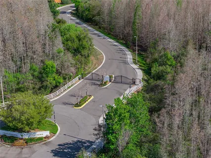 an aerial view of residential houses with outdoor space and trees