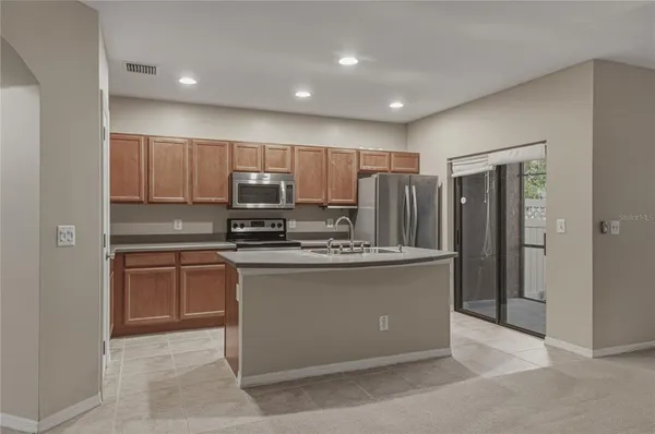 a kitchen with stainless steel appliances granite countertop a refrigerator and a stove top oven