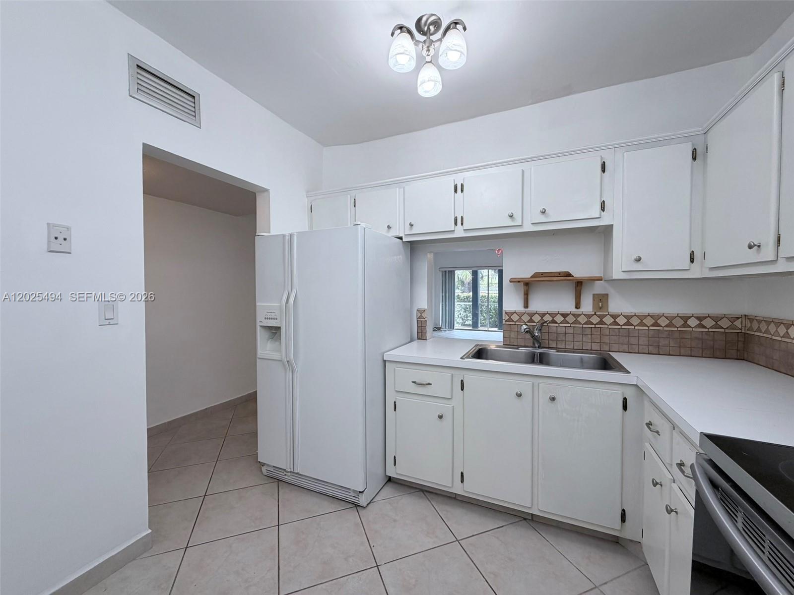 9159 Southwest 77th Avenue, Unit 112 Miami, FL 33156 - Photo 11 of 38 a kitchen with a sink window and cabinets
