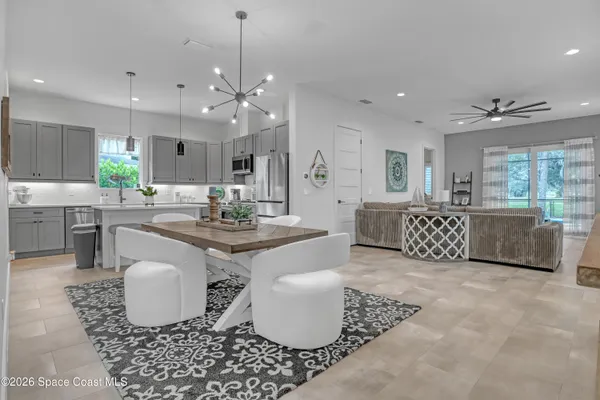 a living room with patio furniture and a chandelier