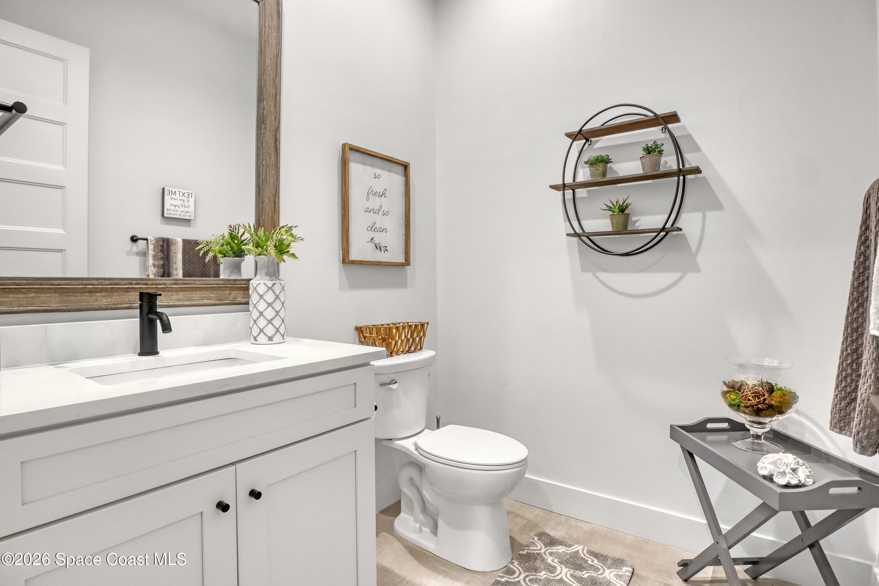 2188 Country Club Road Melbourne, FL 32901 - Photo 26 of 51 a bathroom with a sink a toilet and a mirror