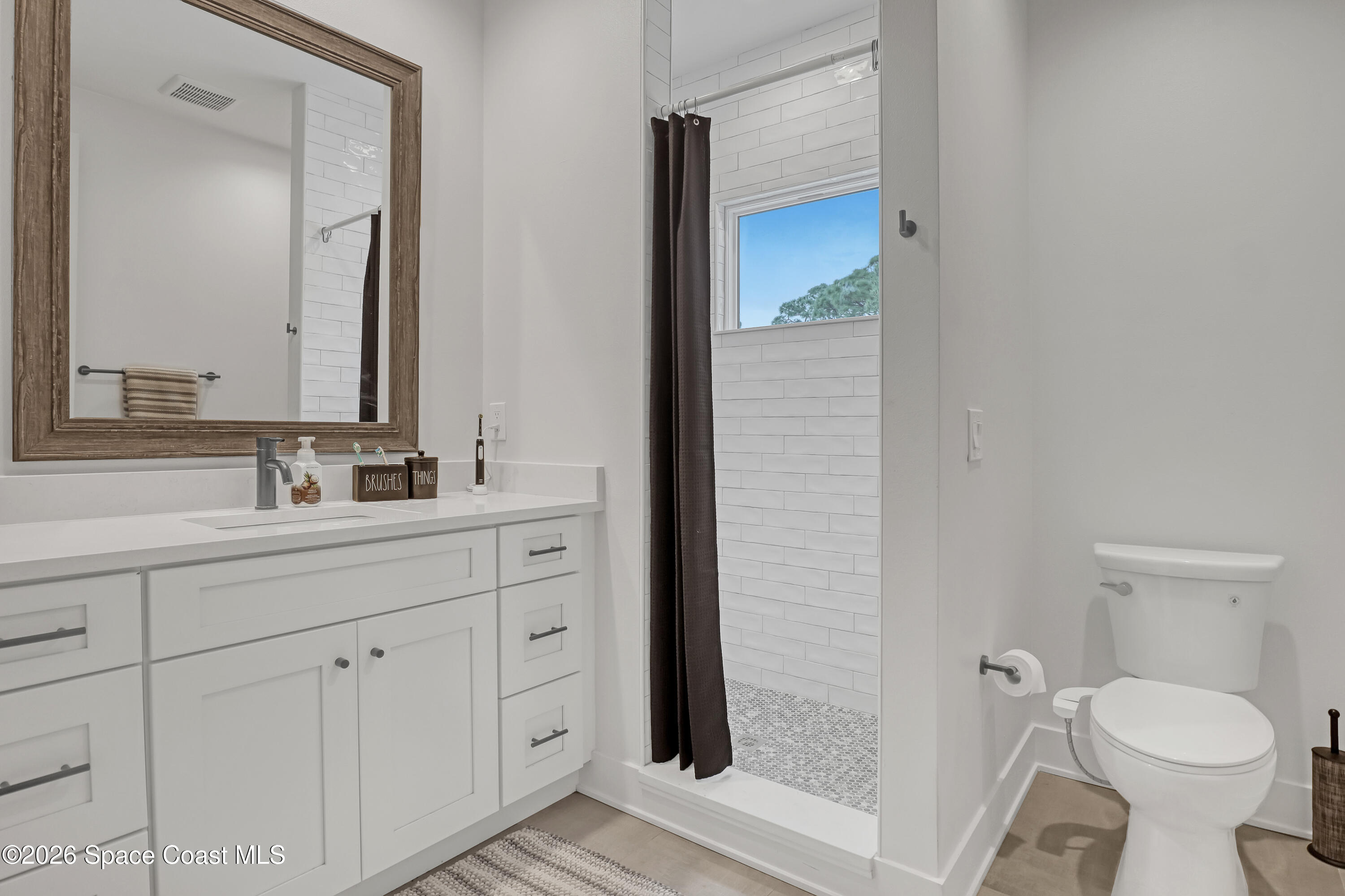 2188 Country Club Road Melbourne, FL 32901 - Photo 33 of 51 a bathroom with a toilet sink and mirror