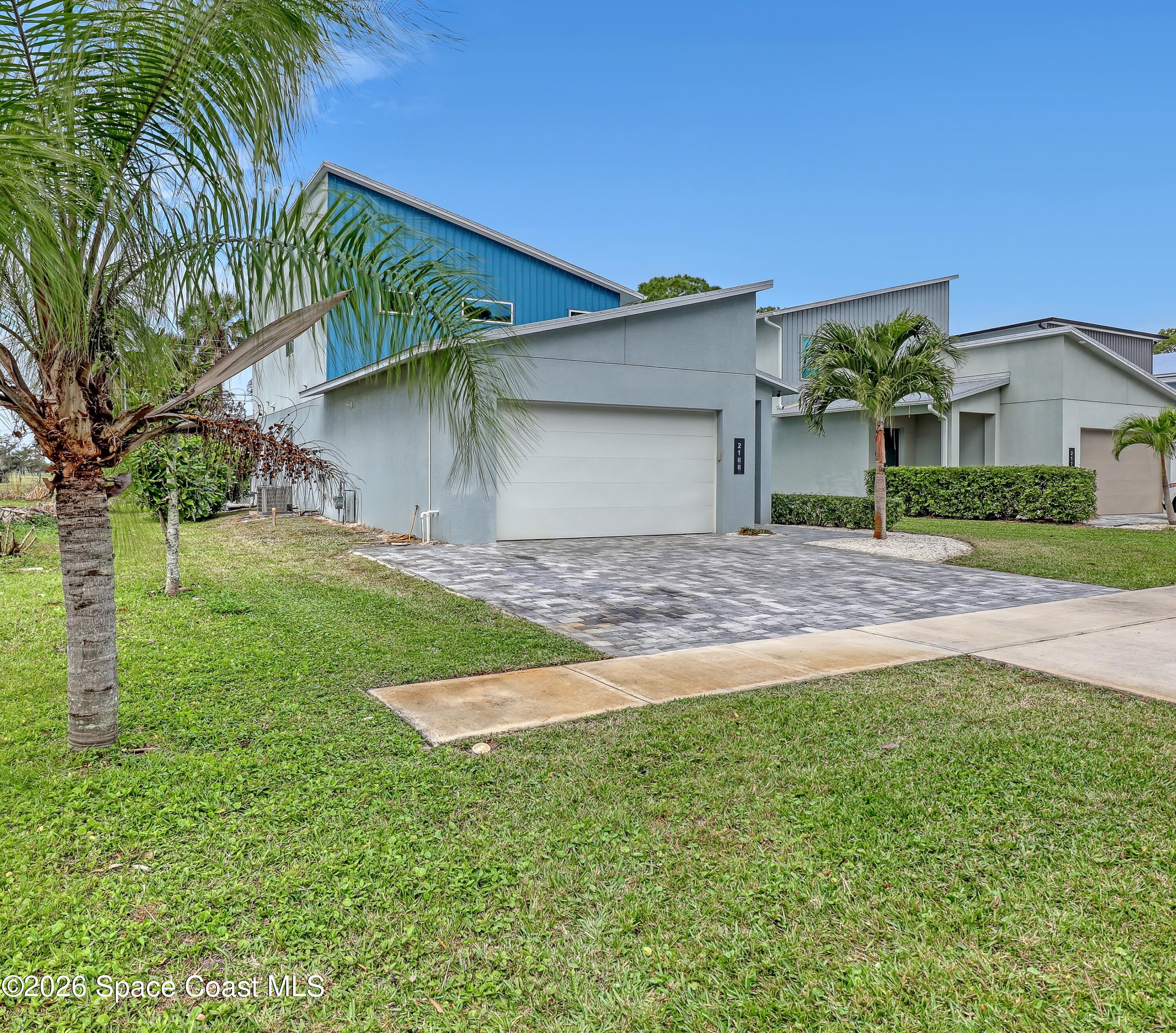 2188 Country Club Road Melbourne, FL 32901 - Photo 4 of 51 a front view of a house with a yard and garage