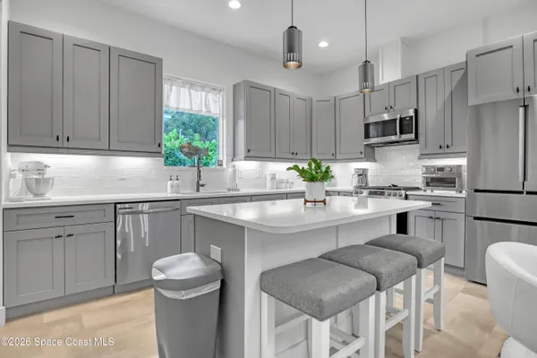 a kitchen with stainless steel appliances a sink stove and refrigerator
