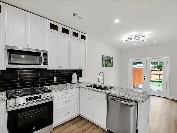 a kitchen with stainless steel appliances granite countertop a refrigerator sink and stove