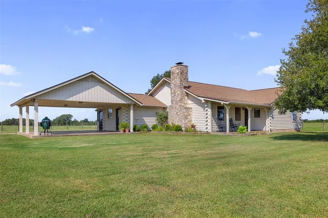 a front view of a house with a yard and trees
