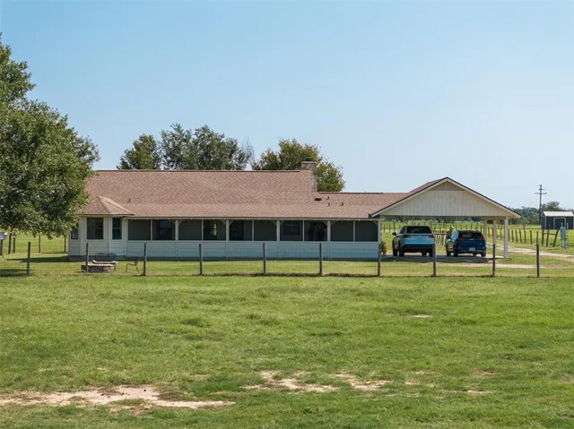 a view of a swimming pool with lawn chairs and a big yard