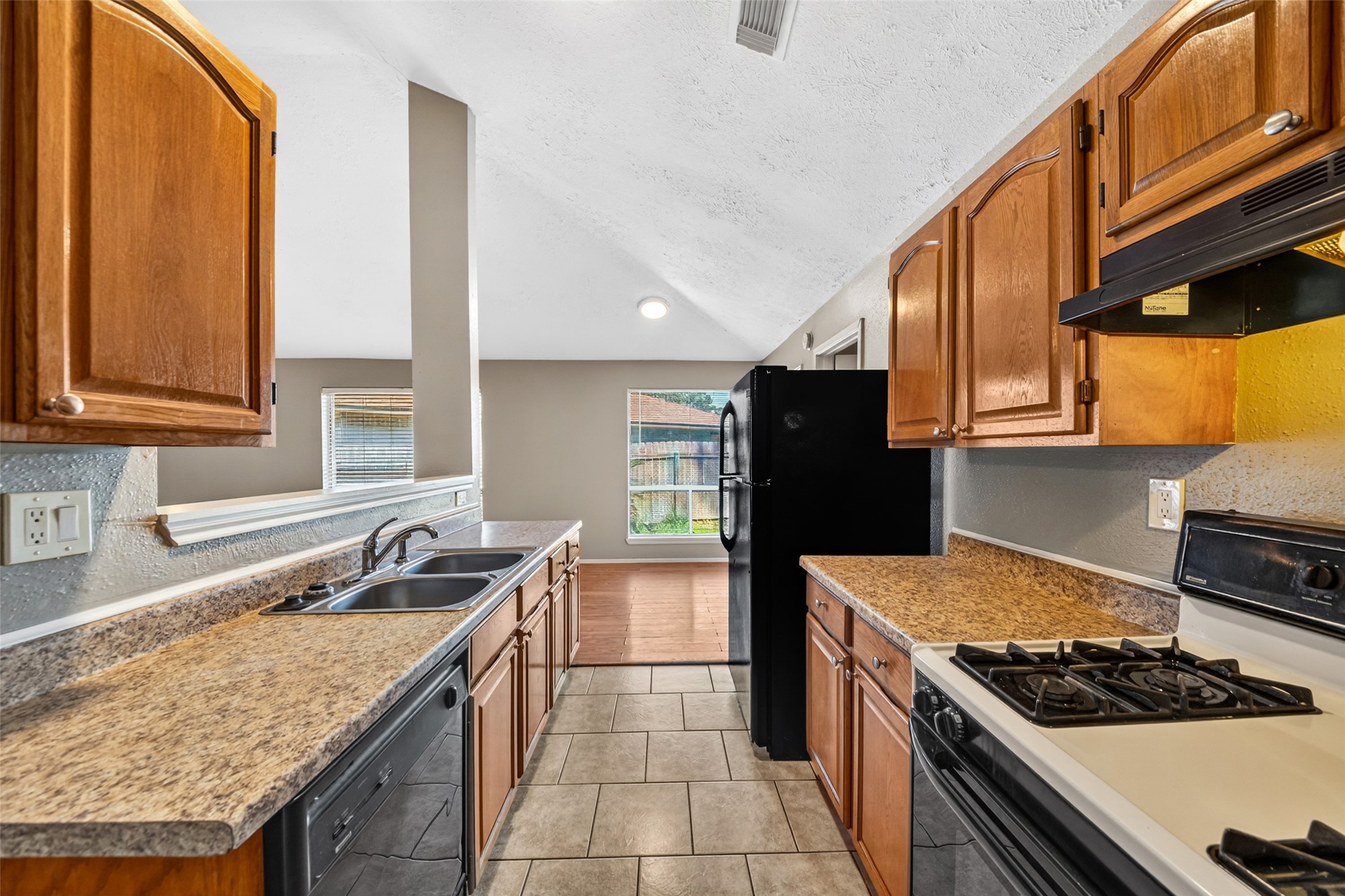 3119 Oak Rock Spring, TX 77373 - Photo 12 of 25 a kitchen with a stove a sink and a refrigerator