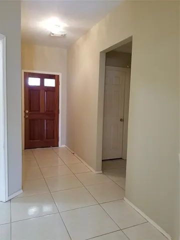 a view of an empty room with closet and a bathroom