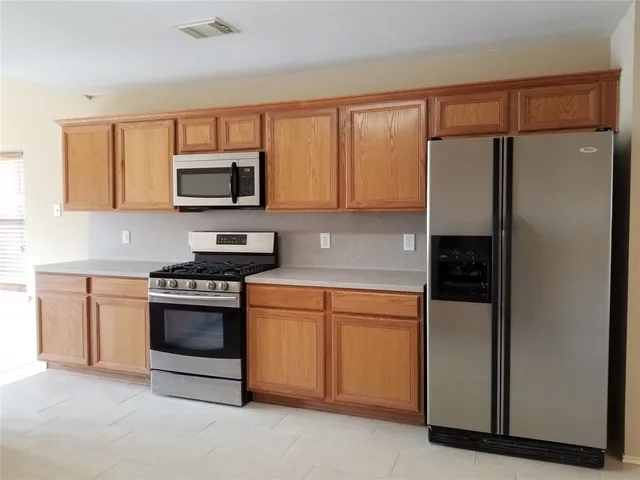 a kitchen with stainless steel appliances granite countertop a refrigerator stove top oven a sink and dishwasher