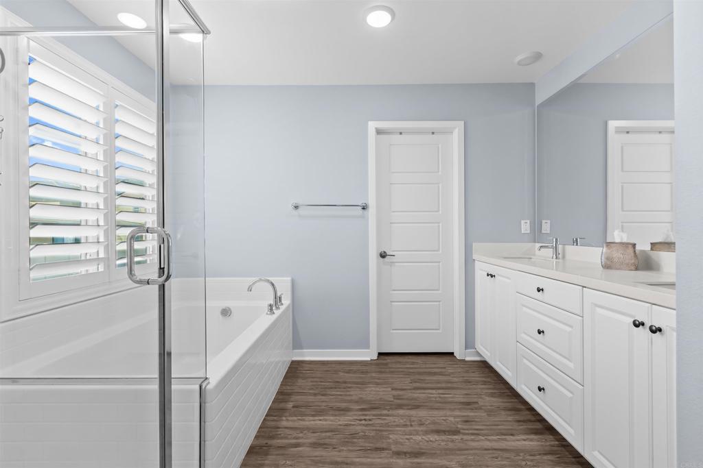 29809 Gypsy Vanner Way Menifee, CA 92584 - Photo 32 of 45 a bathroom with a double vanity sink a mirror and a bathtub