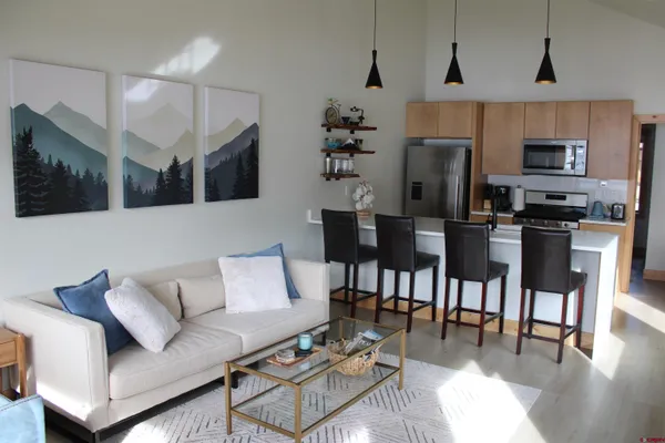 a living room with furniture a flat screen tv and kitchen view