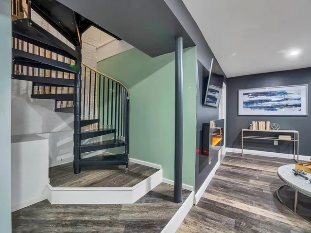 a room with lots of white furniture and a rug