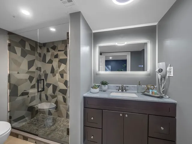 a bathroom with a sink a toilet and shower