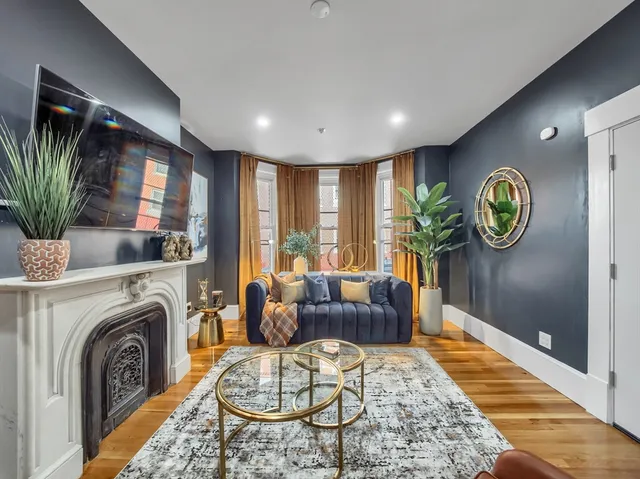 a living room with furniture a rug entryway and a flat screen tv