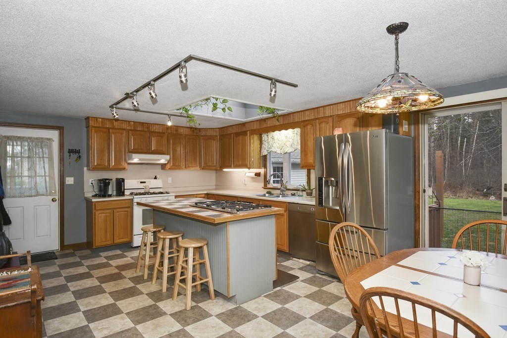 11 Hospital Road Templeton, MA 01436 - Photo 5 of 28 a kitchen with stainless steel appliances granite countertop a stove a refrigerator a kitchen island a stove and a chandelier