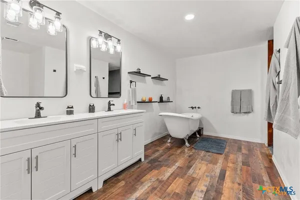 a spacious bathroom with a double vanity sink double mirror and toilet