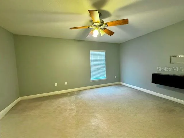 a view of an empty room with a ceiling fan