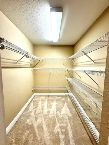 a view of walk in closet with empty racks