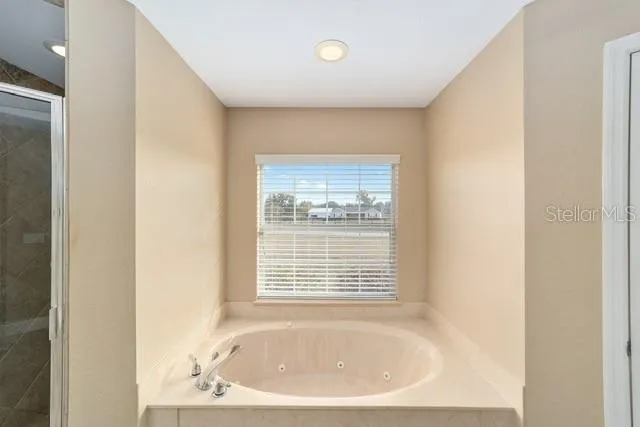 a view of an empty room and chandelier fan