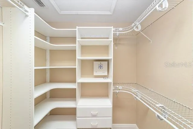 an empty room with windows and chandelier fan