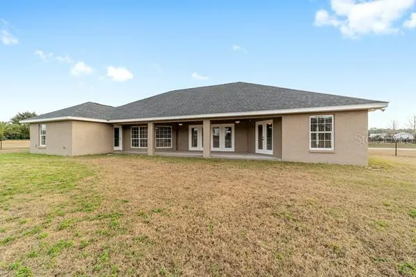 an aerial view of a house with yard and lake view