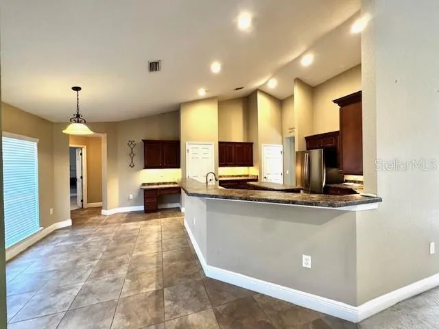 a view of a kitchen with kitchen island a sink stainless steel appliances and cabinets