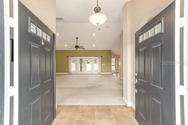 a living room with furniture a chandelier and a potted plant