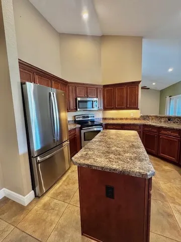 a kitchen with stainless steel appliances granite countertop a refrigerator and a stove top oven