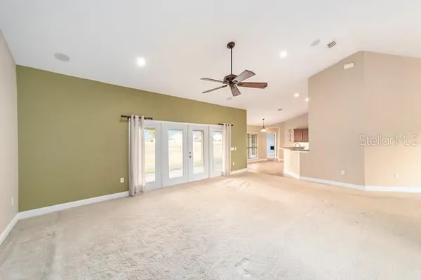 an empty room with a ceiling fan and a window