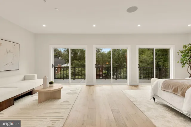 a spacious bedroom with a bed a couch and a view of living room