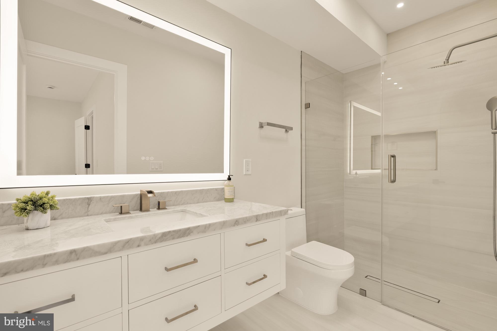 3703 Reservoir Road Northwest Washington, DC 20007 - Photo 46 of 60 a bathroom with a toilet a sink a mirror a shower a vanity and window