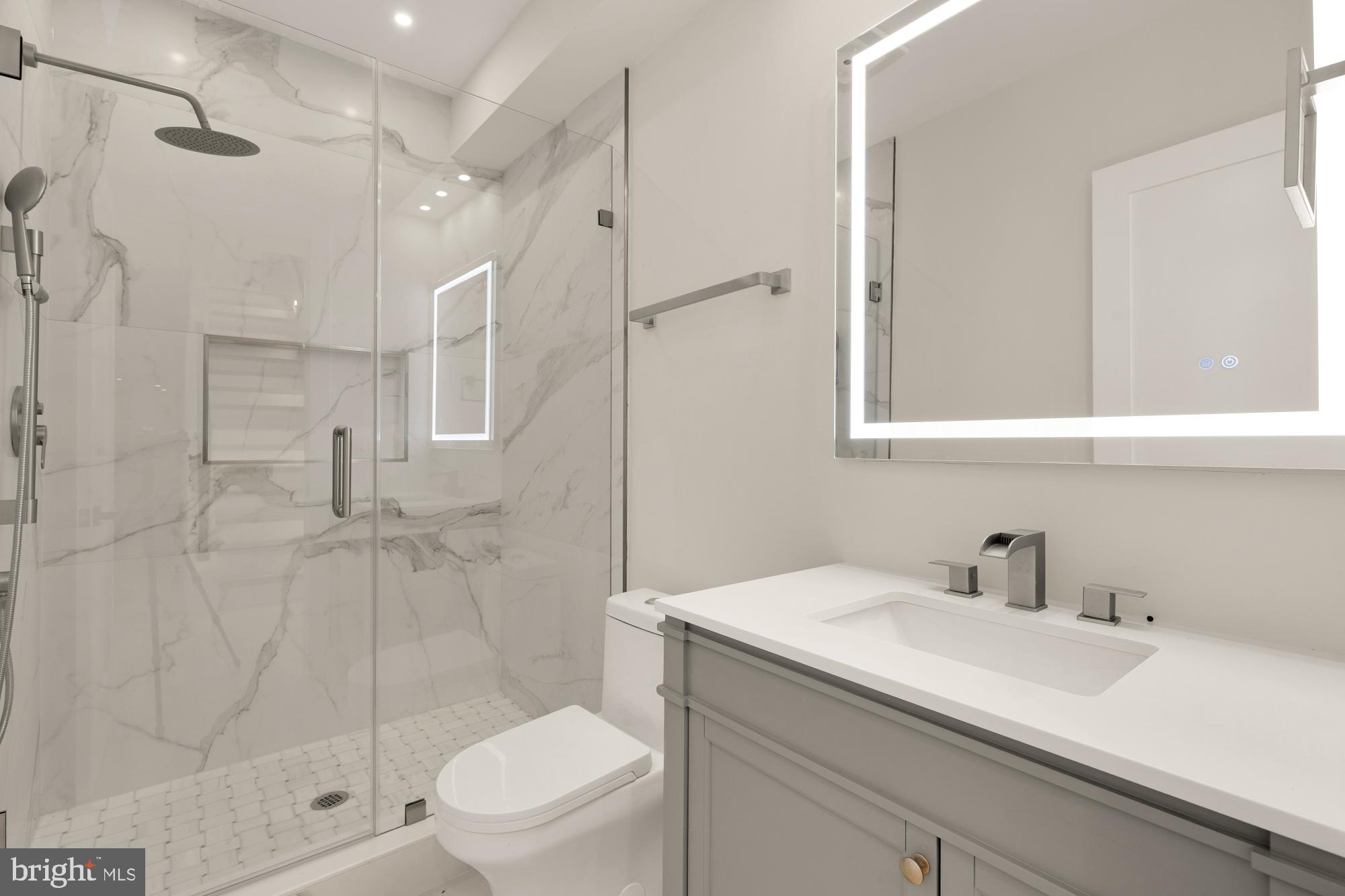 3703 Reservoir Road Northwest Washington, DC 20007 - Photo 54 of 60 a bathroom with a shower sink vanity mirror and toilet